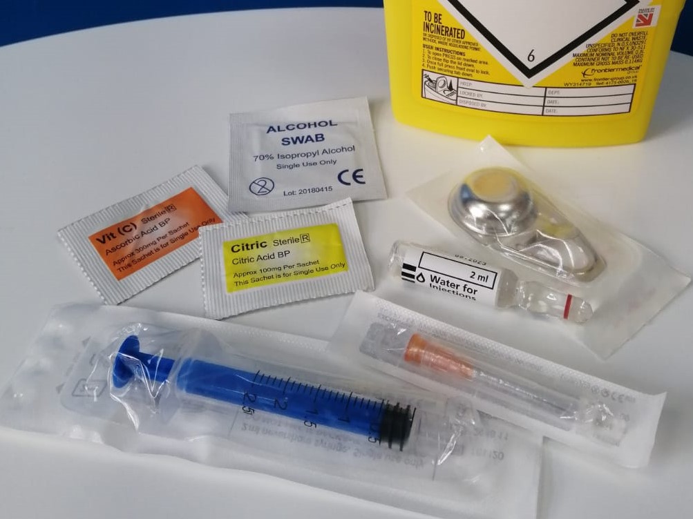 Equipment from a needle exchange including a syringe, sharps bin and vitamin c sachet